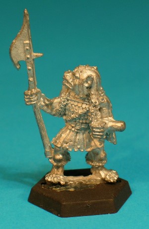 Pose 3, variant E. This variant wears a tatty leather cap with studs and long cheekflaps. His polearm is a glaive-guisarme, with a hooked blade on the far side and a short spike on the nearside. The Gnoll has a broad dog-like face with a short muzzle, and a closed mouth with protruding upper fangs. His head is slightly raised and he looks over his right shoulder. He has no earrings.